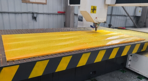 Yellow recycled plastic sheet being processed in factory